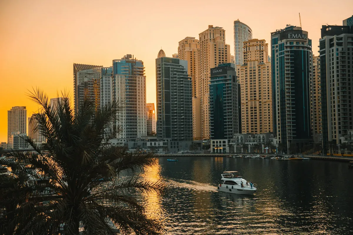 Die Türme der Dubai Marina im Abendlicht, davor eine Yacht