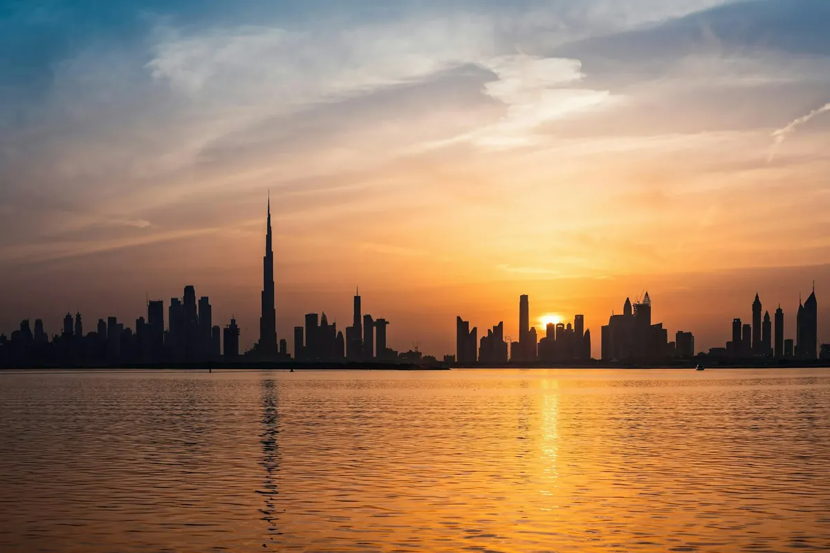Die Skyline von Dubai bei Sonnenuntergang über dem Wasser